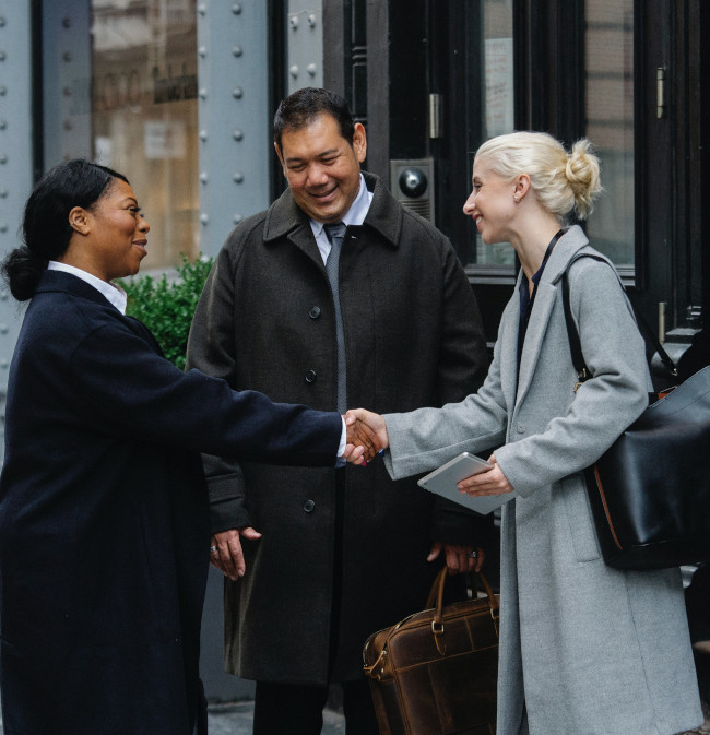 A group meeting and shaking hands outside